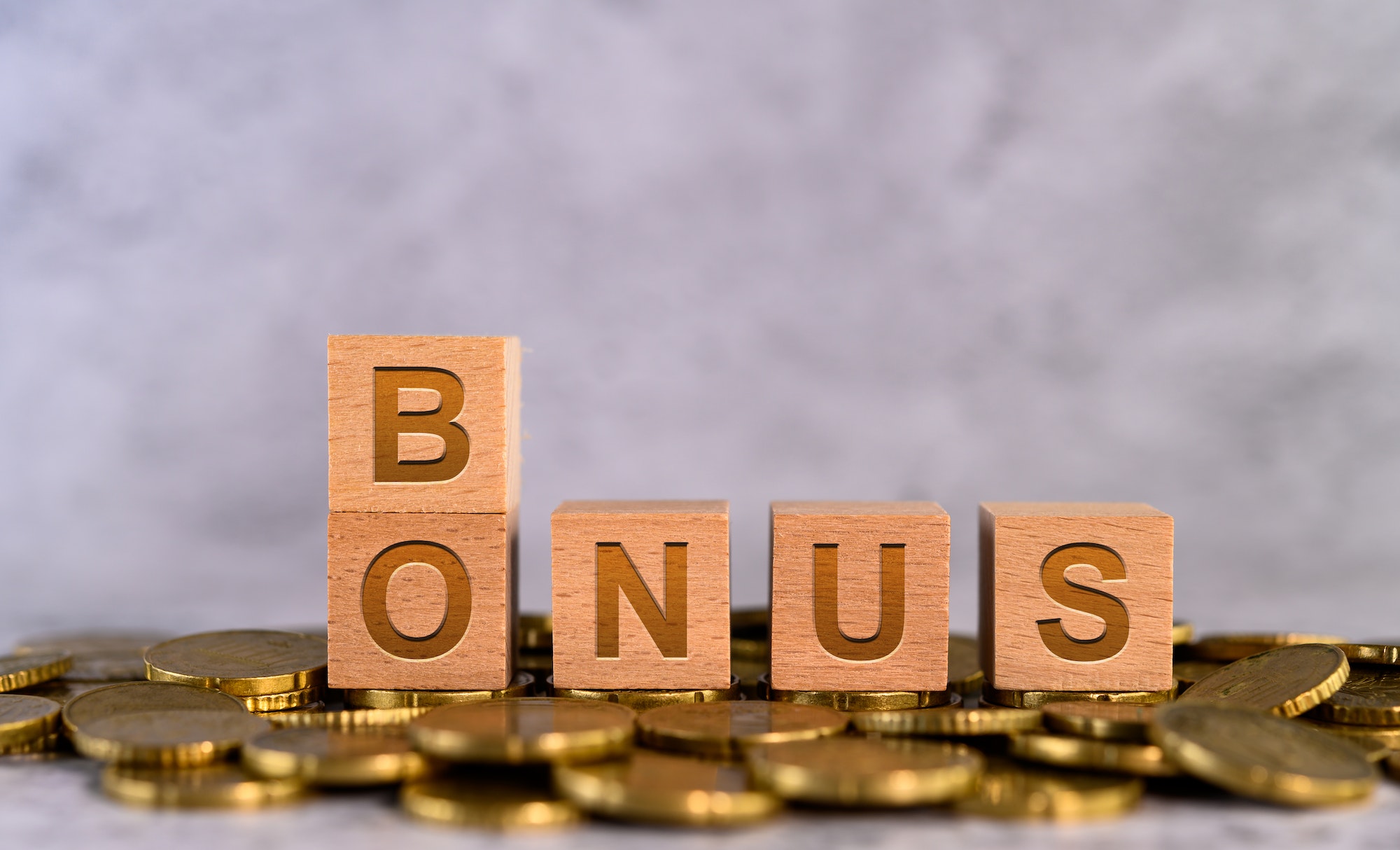 Bonus word alphabet wooden cube letters placed on a gold coin